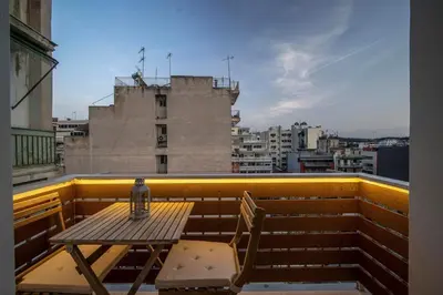 a table and chairs on a balcony with a view at Acropolis Sneak peak 5th floor in Athens