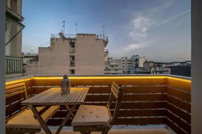a table and chair on a balcony with a view at Acropolis Sneak peak 5th floor in Athens