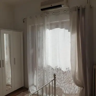 a window with white curtains in a room at Sagma Athens House Metro Panormou in Athens