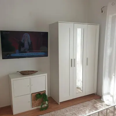 a white cabinet with a tv on a wall at Sagma Athens House Metro Panormou in Athens