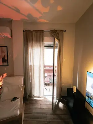 a living room with a window and a couch and a television at 22st Phoenix in Athens