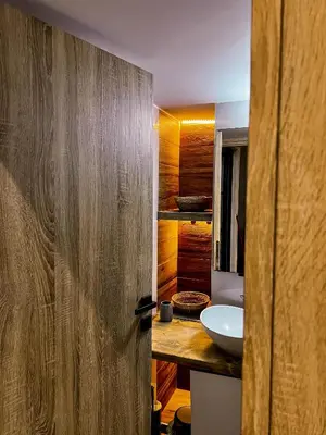 a bathroom with a sink and a wooden door at 22st Phoenix in Athens