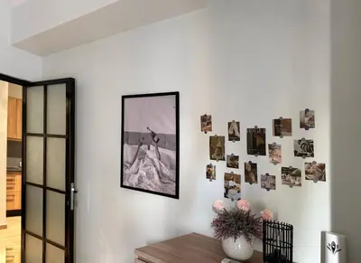 a room with a white wall with pictures on it at 22st Phoenix in Athens