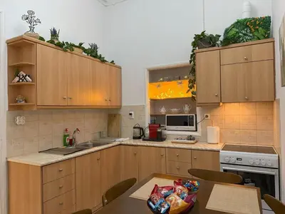 a kitchen with wooden cabinets and a table with a bag on it at Neoclassical Royal Palace next to Acropolis in Athens