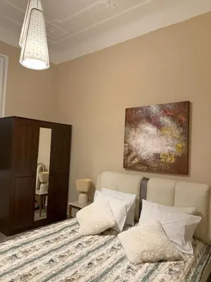a bedroom with a bed and a painting on the wall at Neoclassical Royal Palace next to Acropolis in Athens