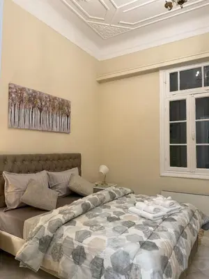 a bedroom with a bed and a painting on the wall at Neoclassical Royal Palace next to Acropolis in Athens