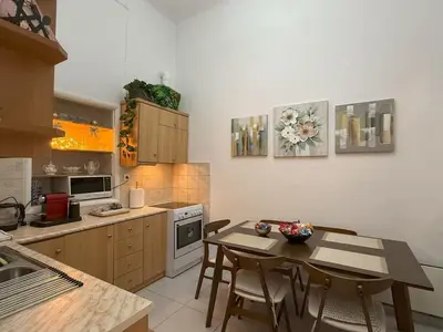 a kitchen with a table and chairs in a kitchen at Neoclassical Royal Palace next to Acropolis in Athens