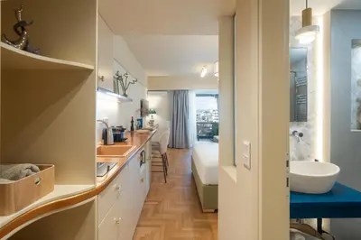 a bathroom with a sink and a bed in a room at Aelia-Smart central beach flat in Athens
