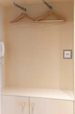 a kitchen with white cabinets and two lights on the ceiling at Aelia-Smart central beach flat in Athens
