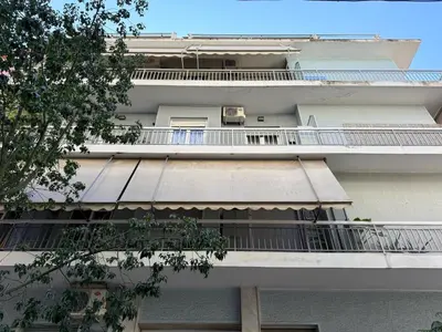 a white apartment building with a balcony and a tree at A27 High-Standing One-Bedroom Apartment in Athens