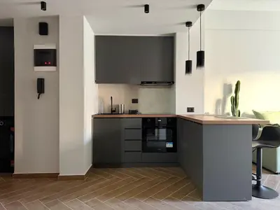 a kitchen with black cabinets and a counter top at A27 High-Standing One-Bedroom Apartment in Athens