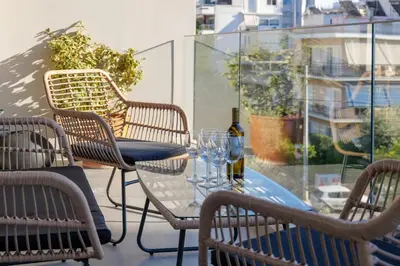 a table with a bottle of wine and chairs on a balcony at Luxurious Athens Residence in Athens