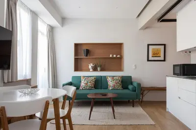 a living room with a green couch and a table at Heart of Athens Suites in Athens