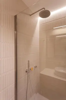 a bathroom with a shower with a glass door at Heart of Athens Suites in Athens