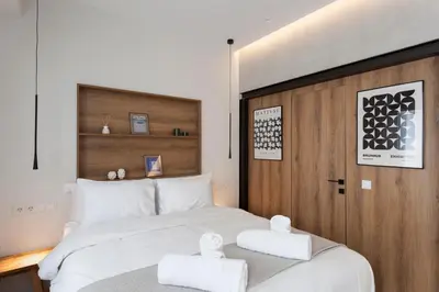 a bedroom with a large bed with two towels on it at Heart of Athens Suites in Athens