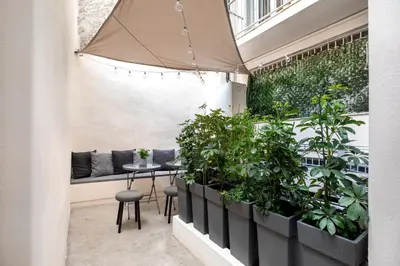 a balcony with plants and a table and a bench at Plaka Clio Apartment by A&A Residences in Athens
