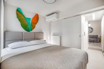 a bedroom with a large bed with a butterfly on the wall at Plaka Clio Apartment by A&A Residences in Athens