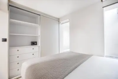 a white bedroom with a bed and a closet at Plaka Clio Apartment by A&A Residences in Athens