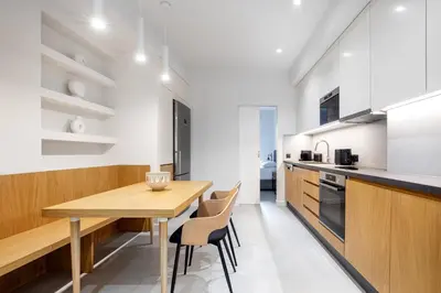 a kitchen and dining room with a wooden table and chairs at Plaka Clio Apartment by A&A Residences in Athens