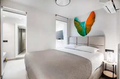 a bedroom with a large bed with a butterfly on the wall at Plaka Clio Apartment by A&A Residences in Athens