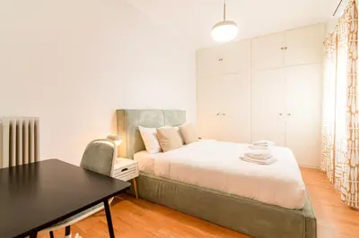 a bedroom with a bed and a table and a chair at Stylish 2-Bedroom Apartment with Big Terrace in Athens in Athens