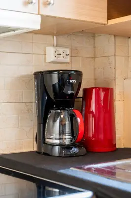 a coffee maker on a counter next to a red mug at Stylish 2-Bedroom Apartment with Big Terrace in Athens in Athens