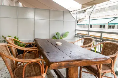 a wooden table and chairs on a balcony at Stylish 2-Bedroom Apartment with Big Terrace in Athens in Athens