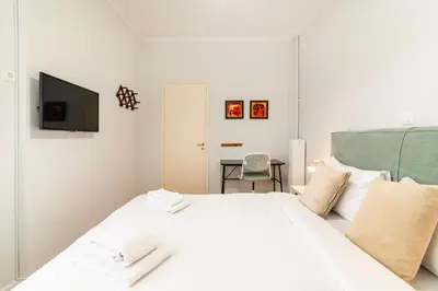 a white bedroom with a white bed and a television at Stylish 2-Bedroom Apartment with Big Terrace in Athens in Athens