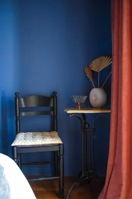 a bedroom with a blue wall with a chair and a table at Classic and spacious apartments in Athens in Athens