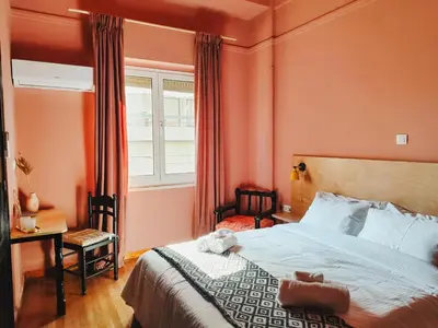 a bedroom with a bed with orange walls and a window at Classic and spacious apartments in Athens in Athens