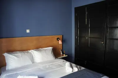a bedroom with a large bed with a blue wall at Classic and spacious apartments in Athens in Athens