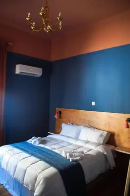 a bedroom with a large bed with a blue wall at Classic and spacious apartments in Athens in Athens