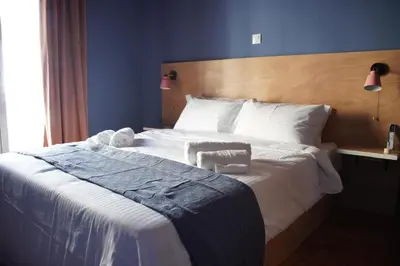 a bedroom with a large white bed with a wooden headboard at Classic and spacious apartments in Athens in Athens