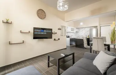 a living room with a couch and a tv on a wall at Luxury Athens Central in Athens