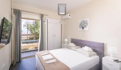 a bedroom with a white bed and a large window at Luxury Athens Central in Athens