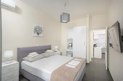 a white bedroom with a bed and a bathroom at Luxury Athens Central in Athens