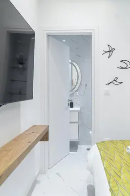 a white bedroom with a bed and a mirror at Diamond Downtown Kolonaki in Athens