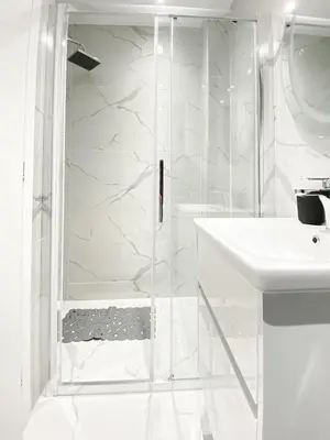 a white bathroom with a shower and a sink at Diamond Downtown Kolonaki in Athens