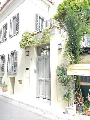 a white house with a gray door and plants at Evangelia1 Comfortable room, Exquisite View in Athens