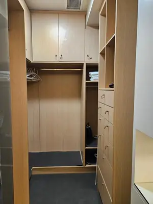 a walk in closet with wooden cabinets at Evangelia1 Comfortable room, Exquisite View in Athens