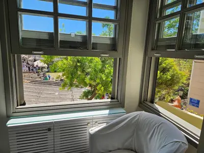 a room with two windows and a white bed in front thereof at Evangelia1 Comfortable room, Exquisite View in Athens