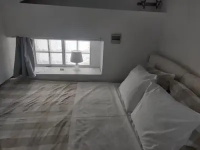 a white bedroom with a bed and a window at Evangelia2 The 