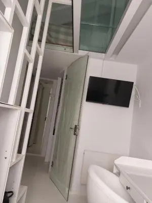 a bathroom with a toilet and a tv on the wall at Evangelia2 The 