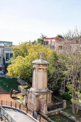a stone monument in a park with trees and buildings at Evangelia3 Attic with Amazing View Patio in Athens
