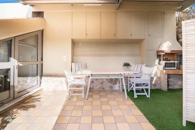 a patio with a table and chairs on a lawn at Evangelia3 Attic with Amazing View Patio in Athens