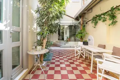 a room with a checkered floor and tables and plants at Evangelia3 Attic with Amazing View Patio in Athens