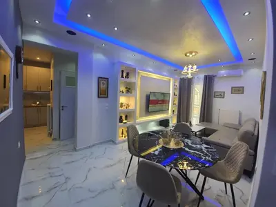 a living room with a table and chairs and a couch at Apartment fbi2 in Athens