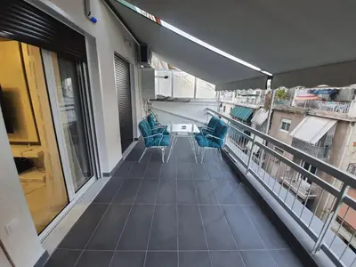 a balcony with blue chairs on a building at Apartment fbi2 in Athens