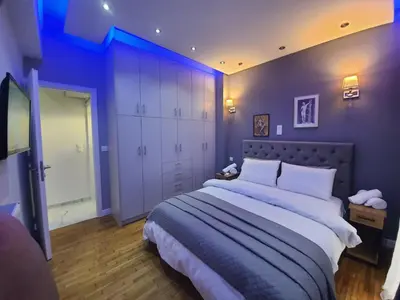 a bedroom with a large bed with purple walls at Apartment fbi2 in Athens