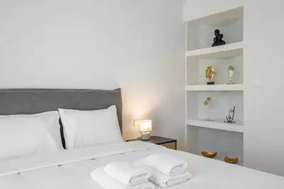 a bedroom with a white bed with towels on it at Bivium Suites by LobbySquare in Athens